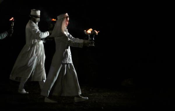 Zoroastrian priests prepare to set fire to a pile of wood