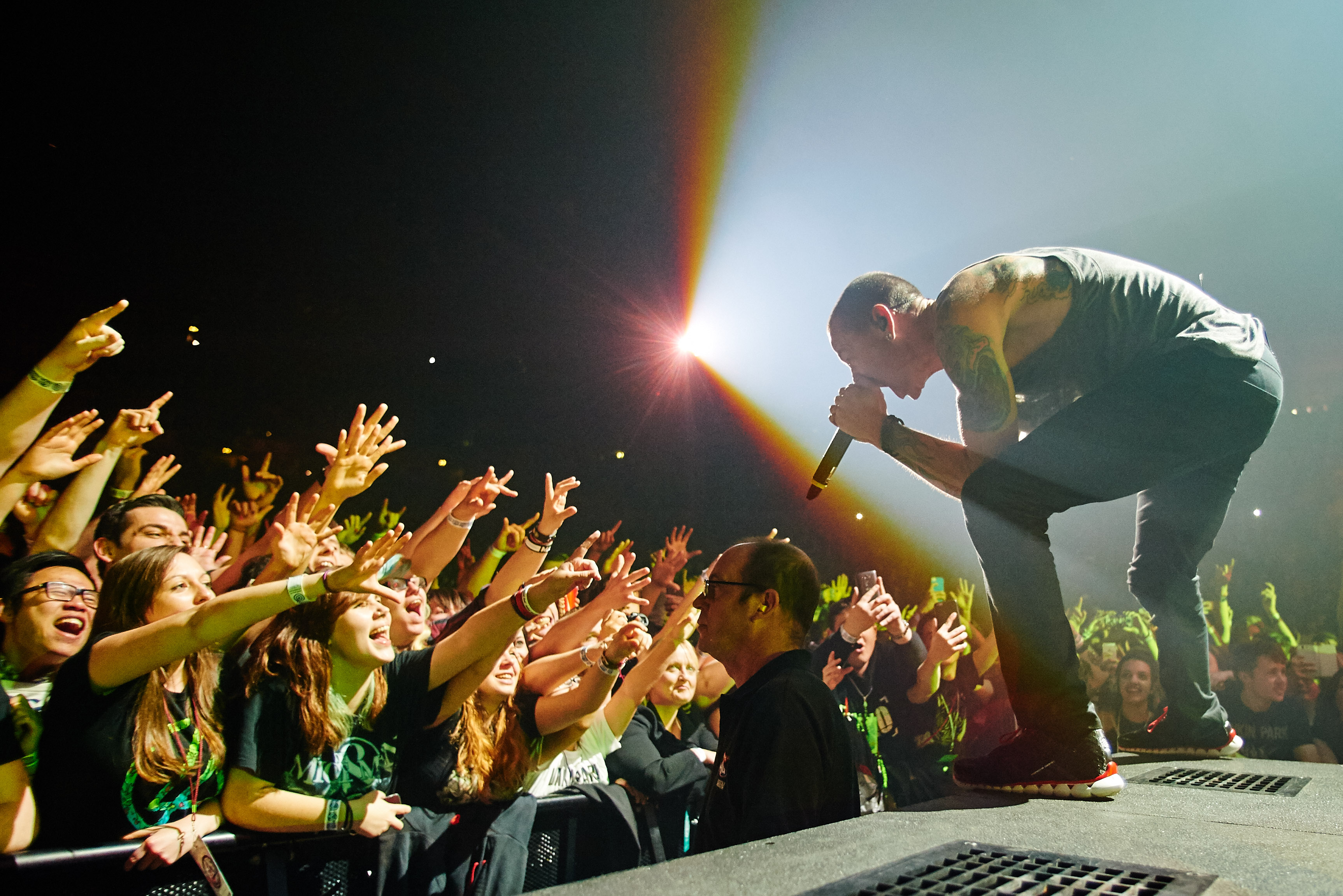 Chester Bennington leans down to a screaming crowd from on stage