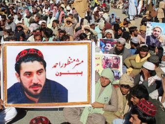 Supporters carry a poster of Manzoor Pashteen (C), the Chief of Pashtun Protection Movement (PTM), during a demonstration in Chaman. (IMAGE: AFP FILE)