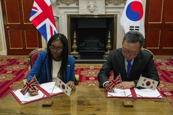 The　UK　Secretary　of　State　for　Business　and　Trade　Kemi　Badenoch　(left),　Shinhan　Bank　CEO　Jung　Sang-hyuk　sign　a　memorandum　of　understanding　at　Mansion　House　on　Nov.　22　(Courtesy　of　Shinhan)