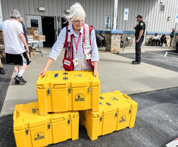 Dee Besecker from Greenville/Mountain Area Chapter of Red Cross distributing hot meals at the Ag Center Shelter post-Hurricane Helene flooding in Asheville, NC