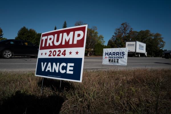 Signs showing support for both Democratic presidential candidate Vice President Kamala Harris and Republican presidential candidate former President Donald Trump sit along a rural highway on September 26, 2024 near Traverse City, Michigan