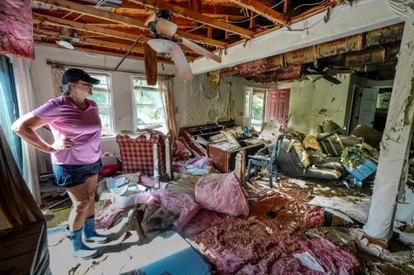 Cindy White surveying the devastation inside her flood-damaged home caused by Hurricane Helene in Morganton, N.C., 2024