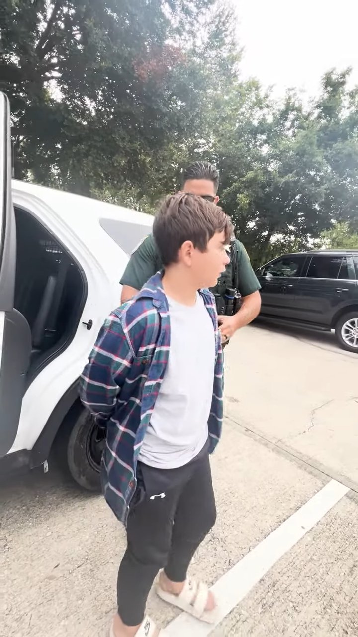 卡洛·“金斯顿”·多雷利被带出警长副手的车辆,手被铐在背后
