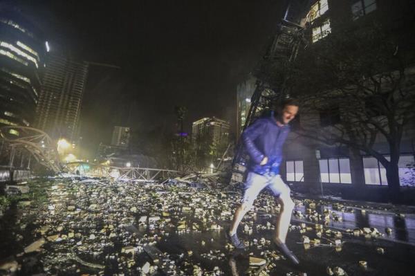 Joe Lindquist, 32, of St. Petersburg, walks over bricks near a fallen crane along 1st Avenue South near the Tampa Bay Times offices in St. Petersburg, Florida, Thursday, October 10, 2024, as Hurricane Milton's strong winds tore through the area. Picture: Chris Urso/Tampa Bay Times via AP