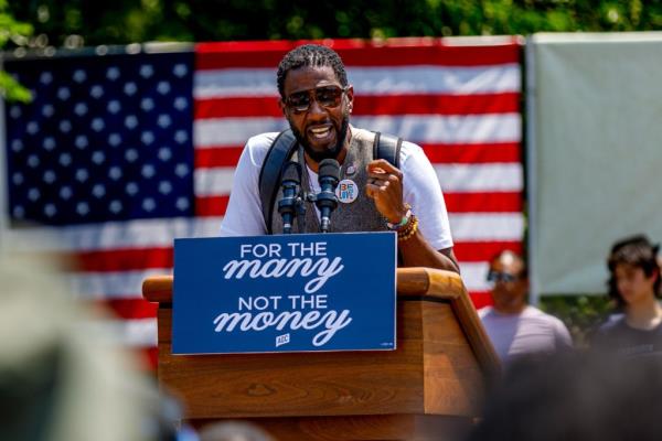 New York City Public Advocate Jumaane Williams speaking into microphones at a podium during a rally and canvass kick-off in the Bronx