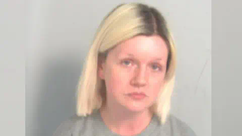 埃塞克斯警方:Virginia McCullough的拘留照片。她有浅金色头发和深色发根。她穿着灰色毛衣,目视前方。