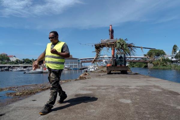 Workers clean up trees and debris on the marina of Saint-Gilles les Bains on the French Indian Ocean island of Reunion
