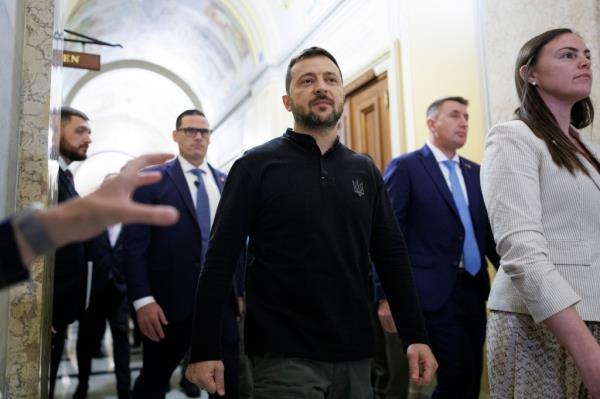 Ukrainian President Volodymyr Zelensky exiting a meeting at the U.S. Capitol, surrounded by staff and security members