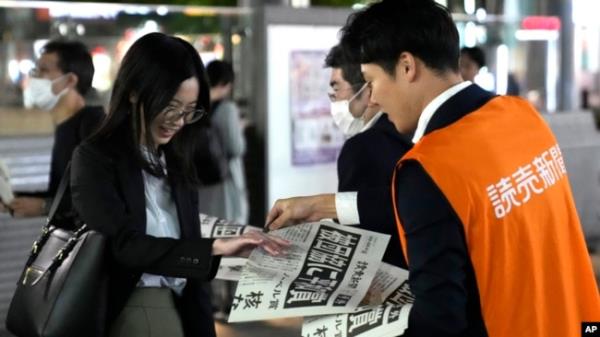 A worker of the Yomiuri Shimbun newspaper hands out copies of an extra version to passersby in Tokyo, Oct. 11, 2024, after Nihon Hidankyo won the Nobel Peace Prize.