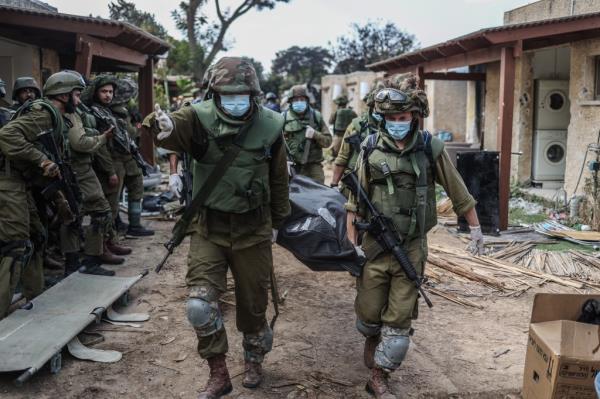 Israeli forces extracting dead bodies of Israeli residents from a destroyed house as fighting between Israeli troops and Islamist Hamas militants continues.