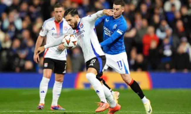 Rayan Cherki is challenged by Tom Lawrence