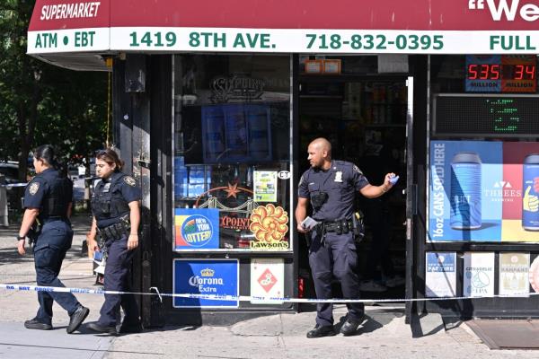 两名警察在布鲁克林南坡的一家熟食店外站立，发生了一起抢劫未遂的枪击事件