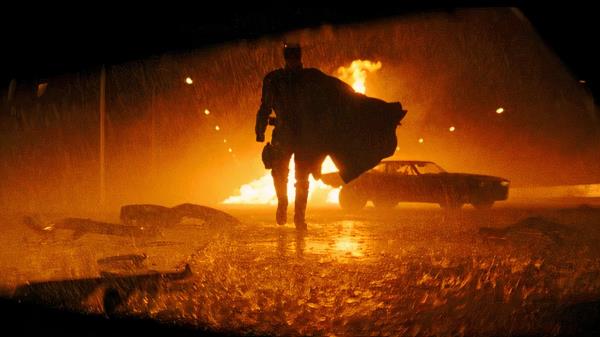 Batman walks away from a flaming car in The Batman