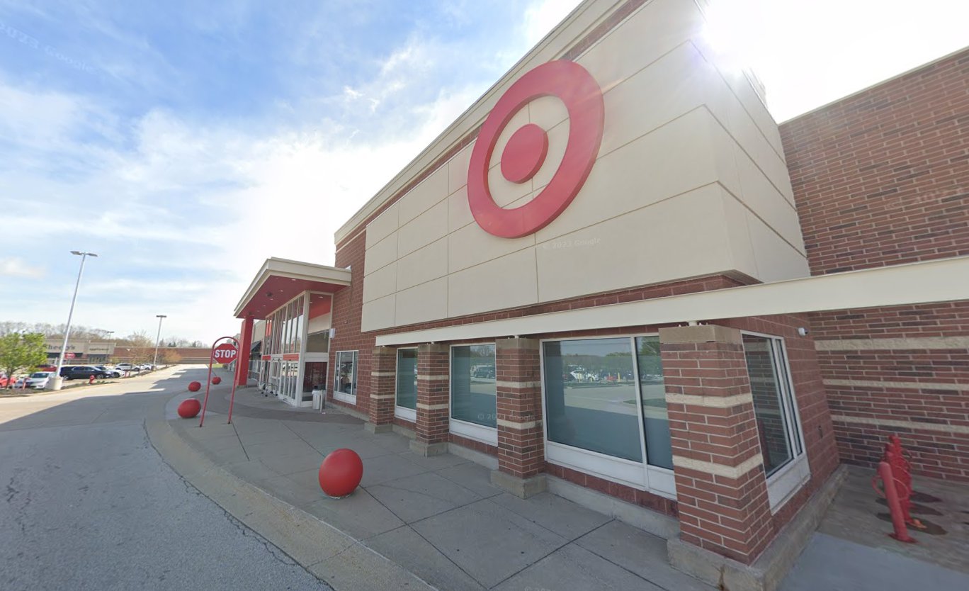 The front of a Target store at an angle shows the bullseye logo and cars in the parking lot at a distance