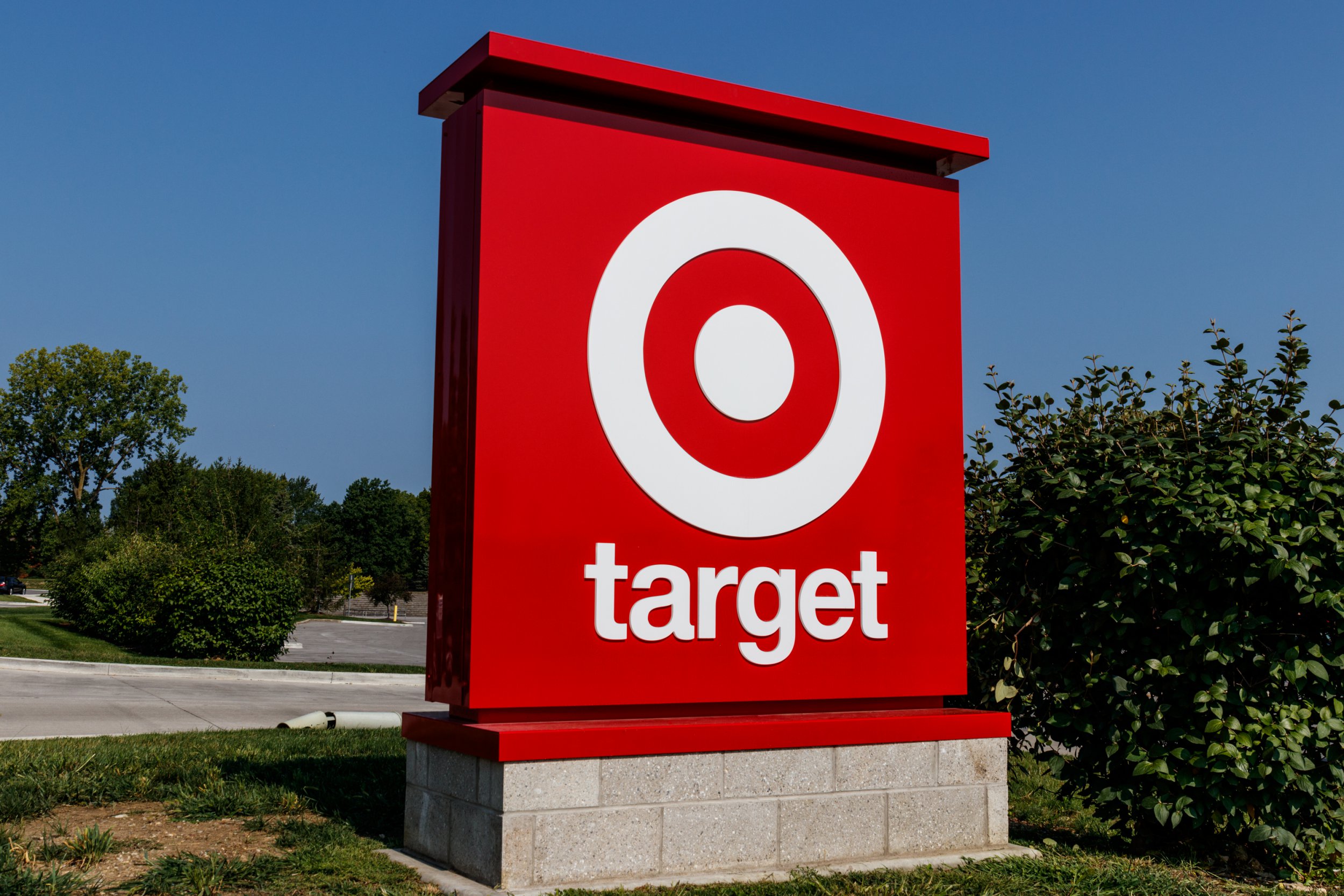 A red and white Target sign surrounded by grass and a road