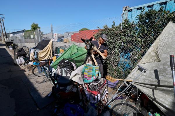 Miguel Angel Gonzalez Martinez, 42, and his dog Lincoln, who moved his makeshift tent to the Mars Ct. alley