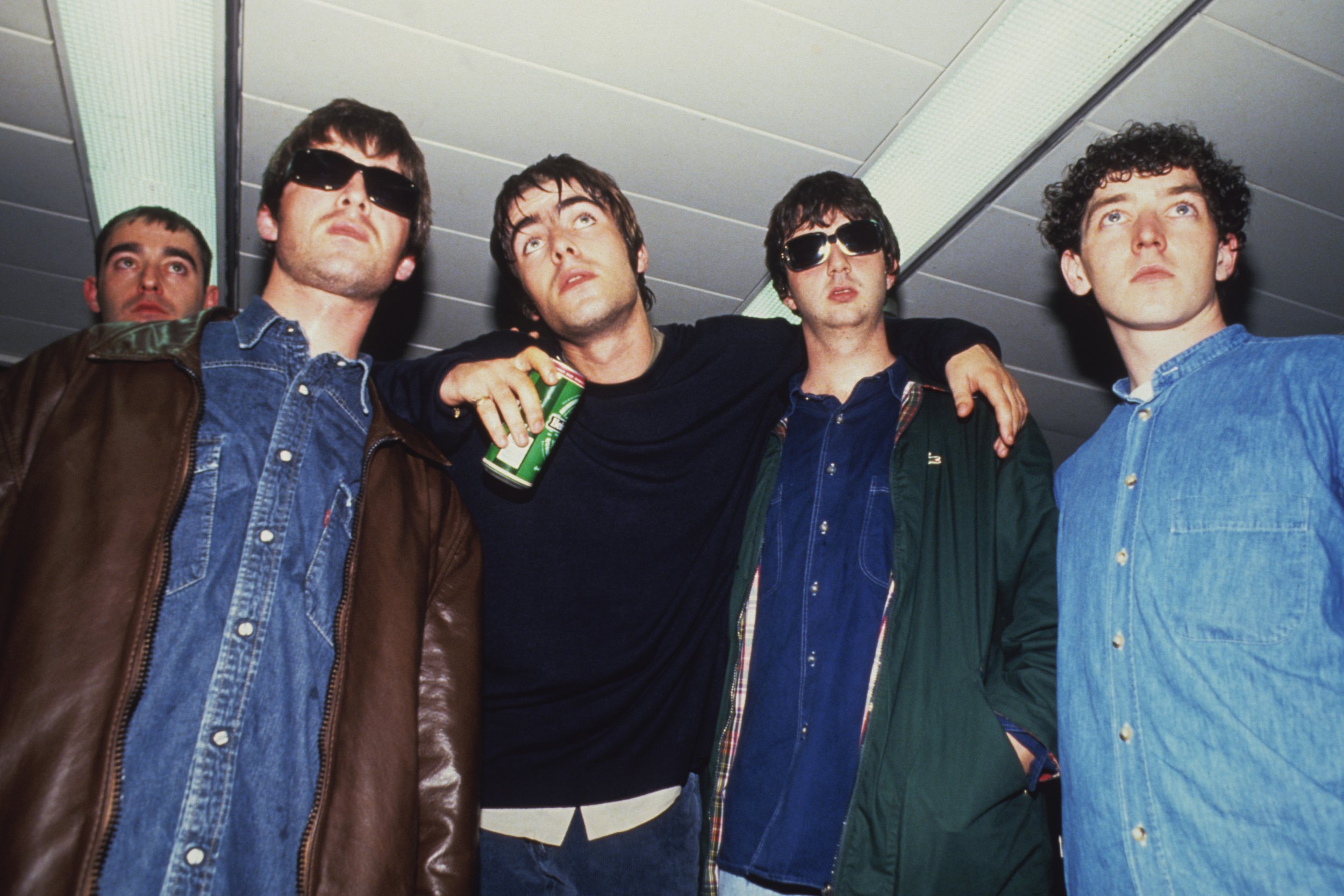 90年代排队摆姿势的绿洲成员Paul Arthurs(又名Bonehead)、Liam Gallagher、Noel Gallagher、Tony McCarroll和Paul McGuigan