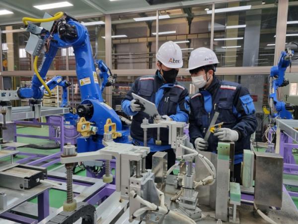 Aju　Steel　workers　check　a　robot　at　an　automated　production　line　at　its　factory