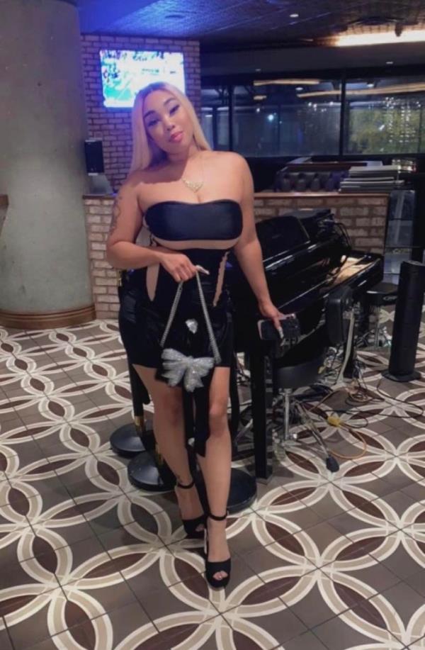 Chanti Dixon in a restaurant wearing a strapless dress holding a purse