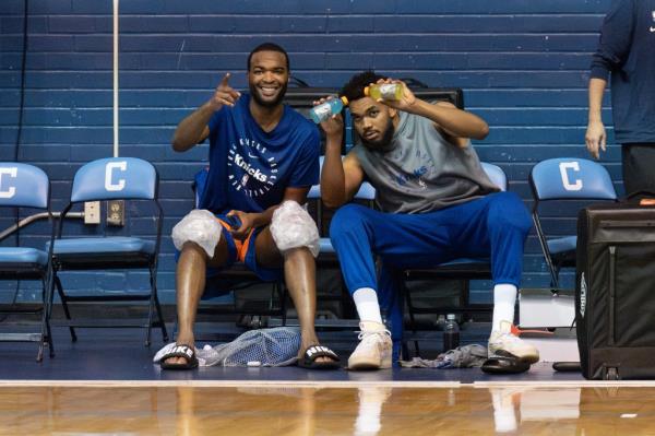 Karl-Anthony Towns, right, and T.J. Warren, left, joke around from the bench during practice