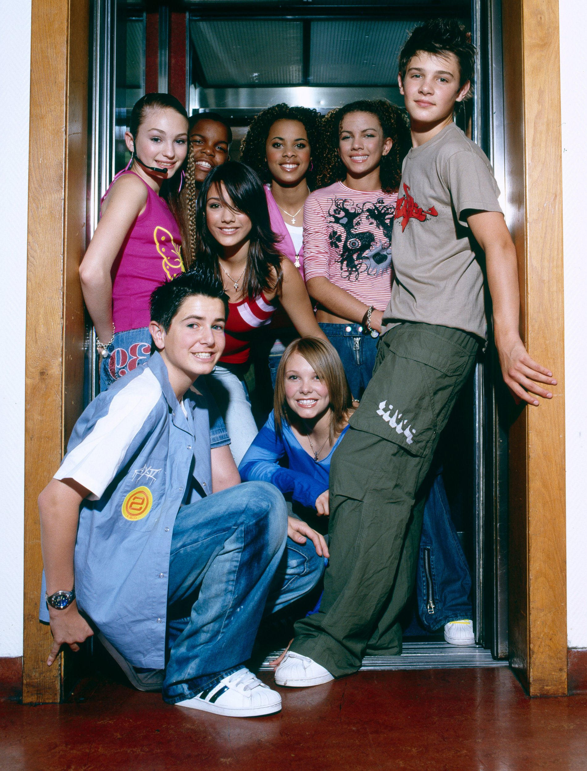 Group portrait of S Club Juniorsbackstage at a TV show Daisy Evans, Jay Asforis, Frankie Sandford, Rochelle Wiseman, Stacey McClean, Calvin Goldspink, Aaron Renfree, Hannah Richings.