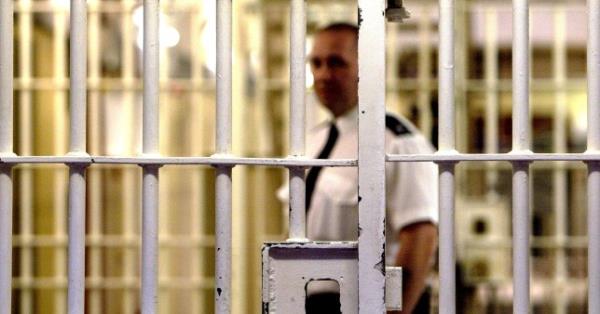 伦敦 - 5月19日：（文件照片）2003年5月19日，伦敦的本顿维尔女王陛下监狱（HMP）的一名监狱警卫站在一扇锁着的大门后面。监狱改革信托（PRT）的一份新报告称，英国监狱的过度拥挤是由于判刑更加严厉，而不是犯罪增加所致。自1991年以来，轻罪犯被监禁的可能性增加了三倍。 （伊恩·沃尔迪/盖蒂图片社拍摄）
