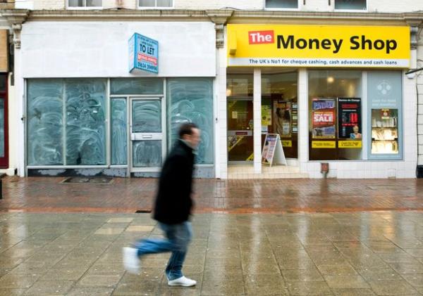 A pedestrian walks past a closed shop in Chatham, U.K