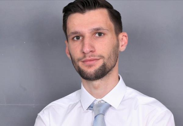 Gezim headshot - he is wearing a white shirt and blue tie
