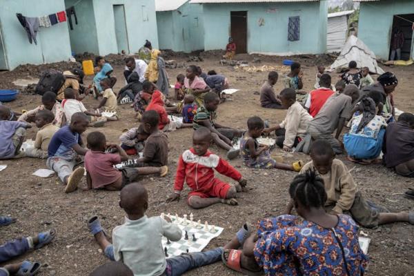 一群小孩坐在地上下棋