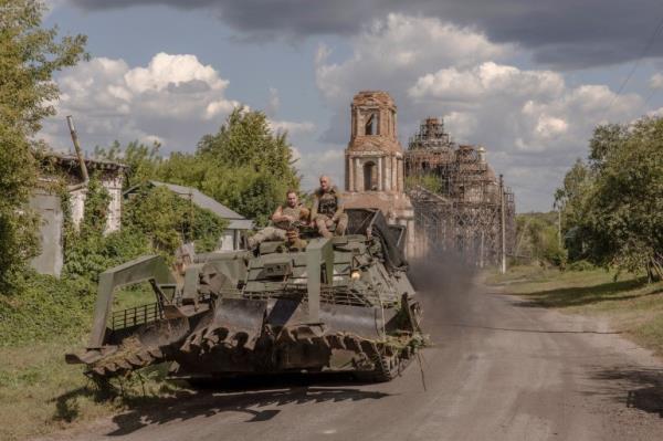Ukrainian servicemen operate an armoured military vehicle on a road near the border with Russia