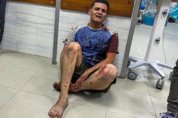 A Palestinian man wounded in an Israeli strike reacts as he sits on the floor at a hospital, amid the ongoing conflict between Israel and Hamas, in Jabalia,