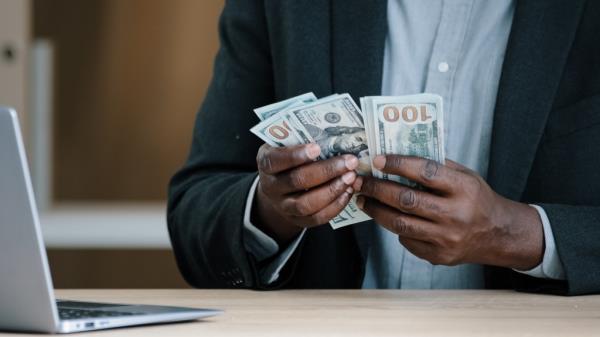 Close up African old male hands with money in office unrecognizable biracial success wealthy businessman holding dollars salary