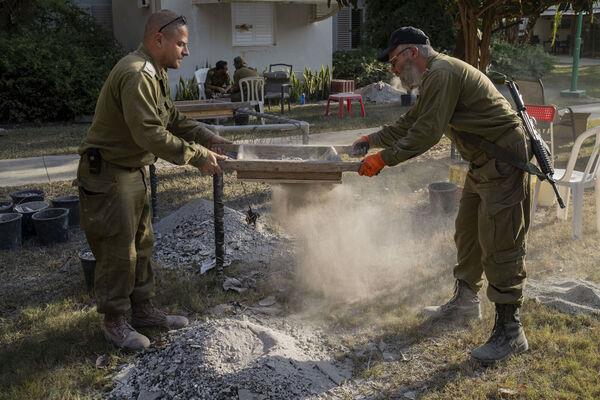 IDF soldiers from the Israeli military rabbinate try to find items that will help identify people killed at Kibbutz Nir Oz, Israel, near the Gaza Strip, Thursday, Nov. 9, 2023. Picture: AP Photo/Bernat Armangue