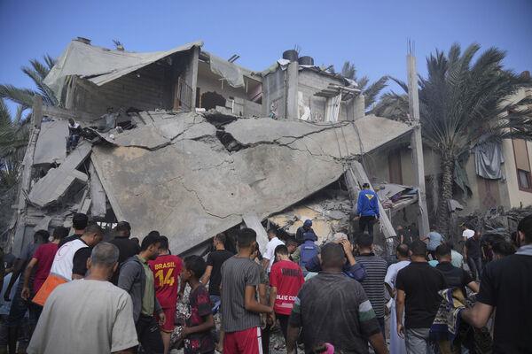 Palestinians look at a building destroyed during an Israeli bombardment in Deir al Balah, Thursday, Nov. 9, 2023. ( AP Photo/Hatem Moussa)