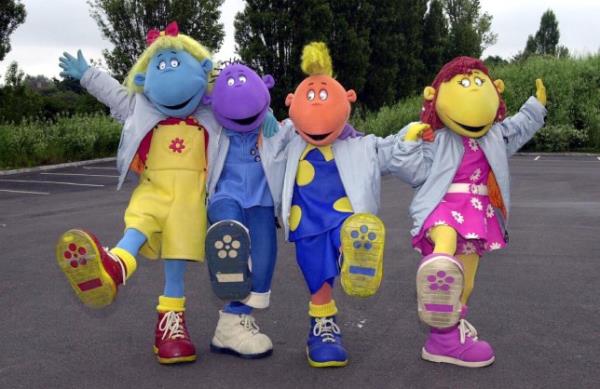 Children's TV favourites, the Tweenies Bella, Milo, Jake and Fizz holding hands in a car park