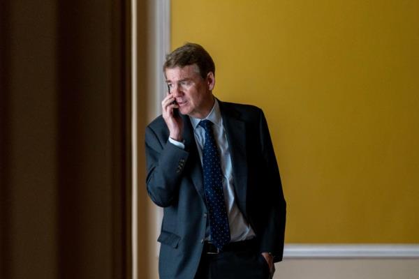 Sen. Michael Bennet, D-Colo., speaks on a cellphone in a hallway as the House approved a 45-day funding bill to keep federal agencies open, Saturday, Sept. 30, 2023, in Washington. The measure, now before the Senate, has been held up by Bennet, who objects to funding for Ukraine not being included in the bill.