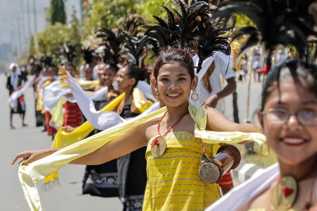 Participants gather on a road as they wait for the arrival of Pope Francis before the welcoming ceremony outside the Presidential Palace in Dili, East Timor