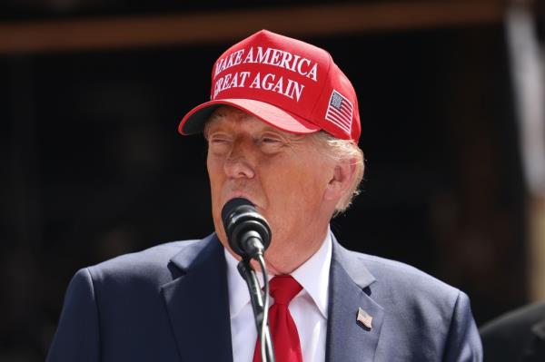 Former U.S. President Donald Trump speaking into a microphone during a visit to Chez What Furniture Store, which was damaged by Hurricane Helene, in Valdosta, Georgia