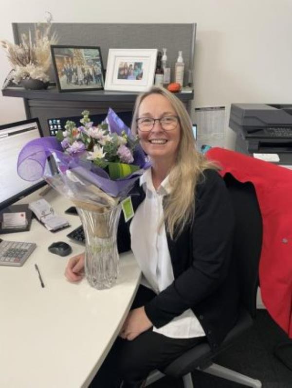 Smiling woman with flowers in an office
