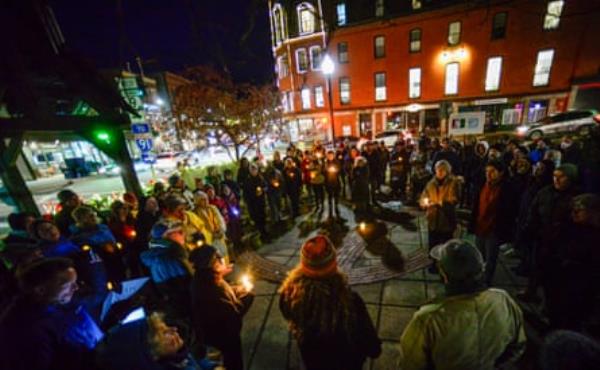 people hold candles at a vigil