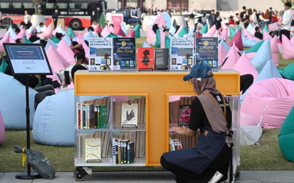 A staff member checks books by Han Kang, who won the 2024 Nobel Prize in Literature, displayed during an outdoor library event at Gwanghwamun square in central Seoul on Oct 11. Photo: AFP