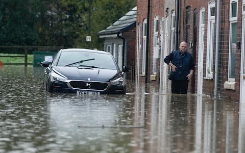 A man walks in flood water on Hawthorne Street in Chesterfield following heavy rain yesterday