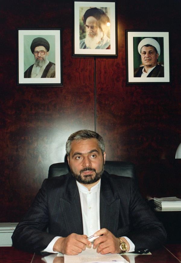 Mousavian at a desk wearing a suit and a gold watch