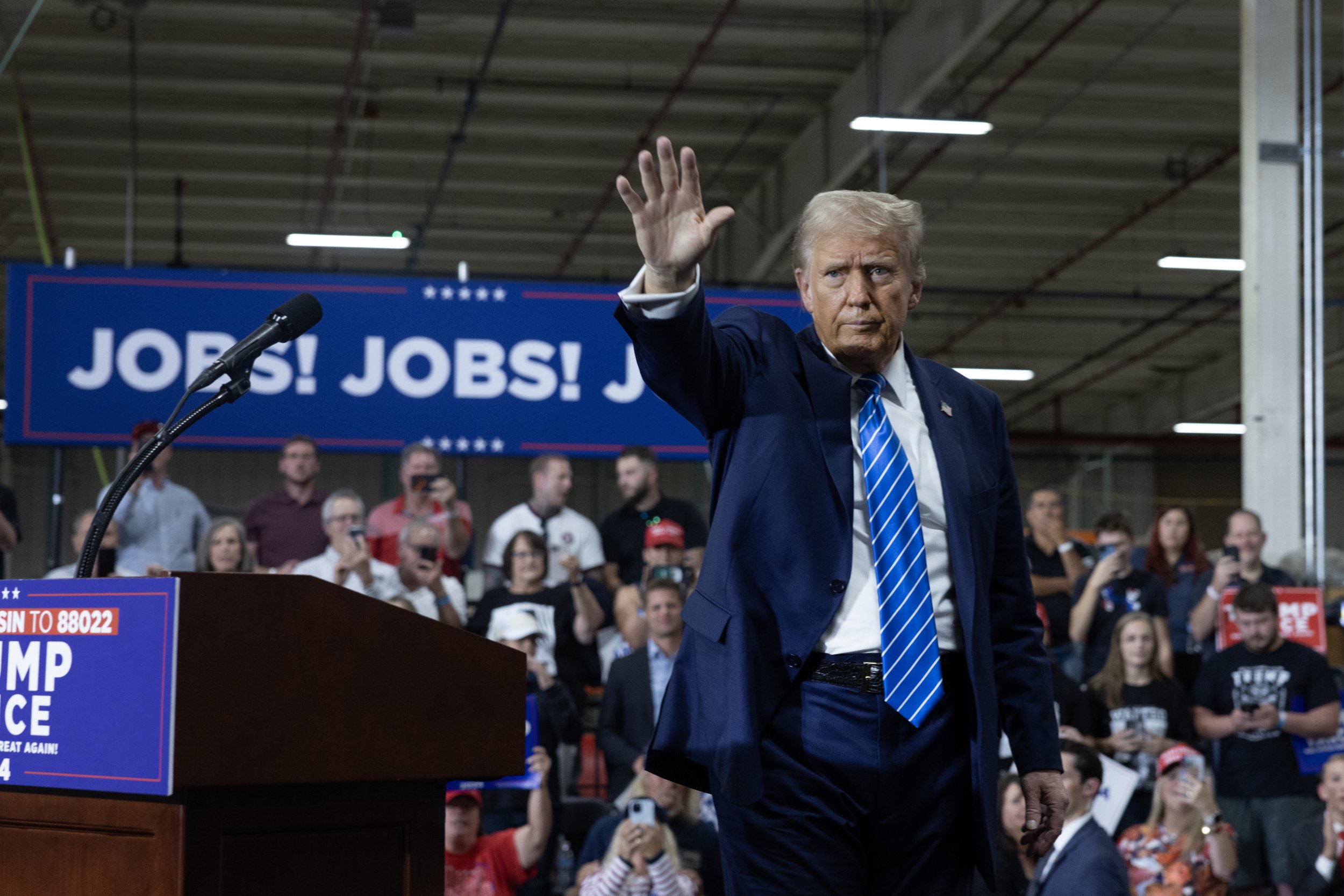 Former President Donald Trump waves as he leaves a campaign event at Dane Manufacturing on October 1, 2024 in Waunakee, Wisconsin