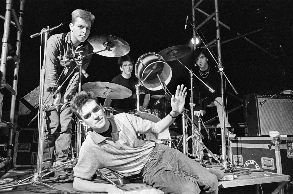史密斯乐队成员Morrissey、Johnny Marr、Andy Rourke和Mike Joyce围绕着舞台上的鼓组
