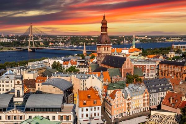 Riga, Latvia: aerial panoramic top view of Old Town and Daugava River at sunset. The tower of Dome Cathedral, a symbol of the Latvian capital city.