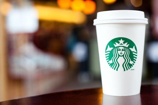 A Grande Starbucks to go cup sitting on a table