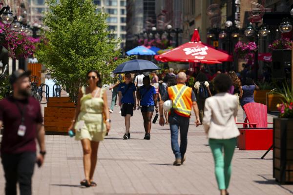 People walking up and down a paved walkway in a city