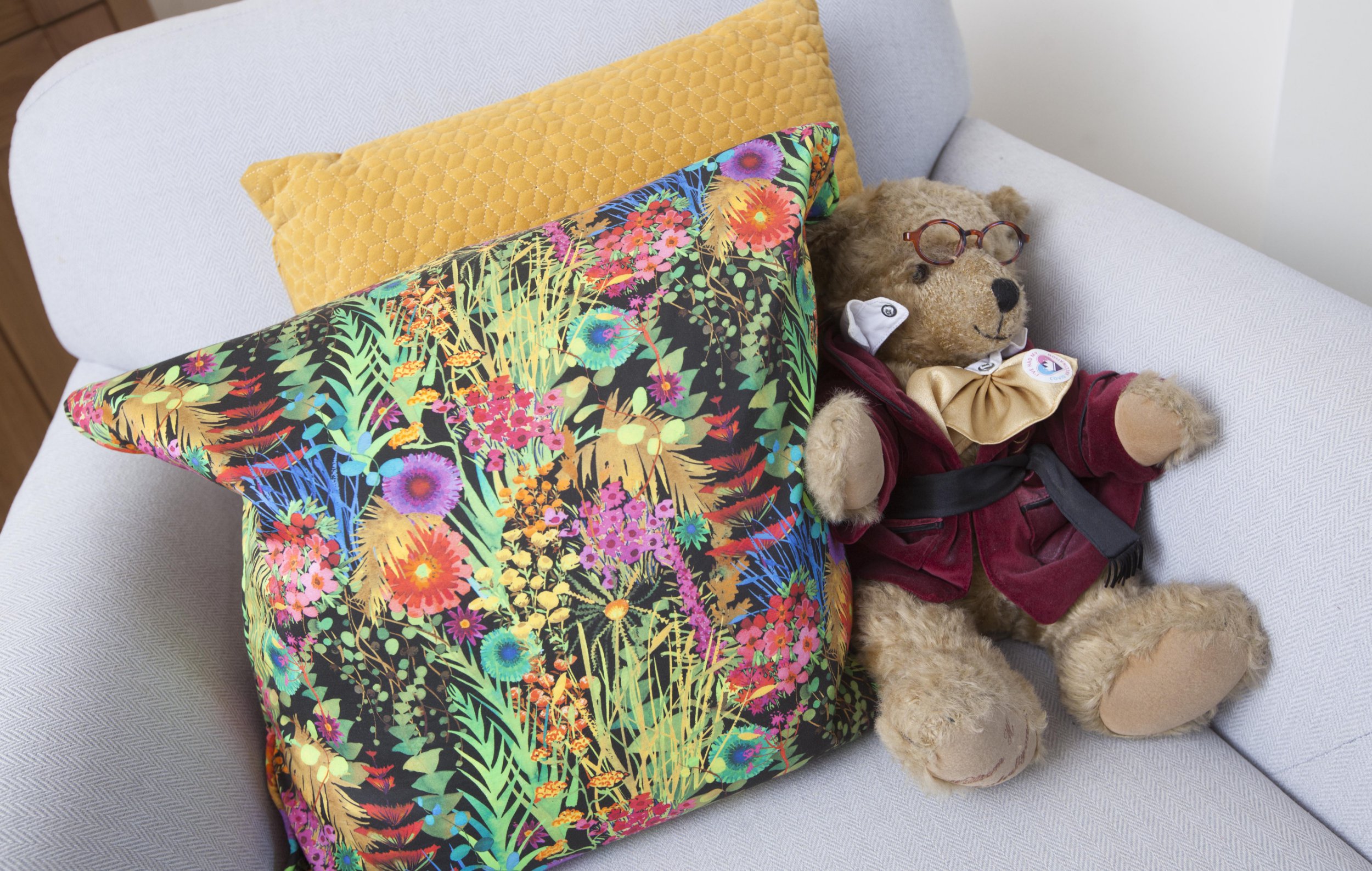 Gill Ross and her apartment in Bagshot, Surrey are the subject of a What I Own feature. This picture shows a bear nestled among colourful cushions in the living room.